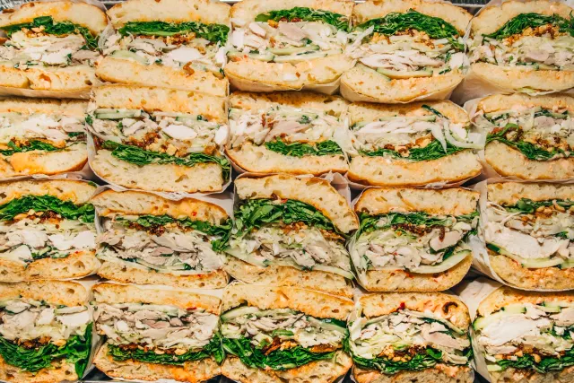 Rows of sandwich halves packed edge to edge, cut sides up, seen from above
