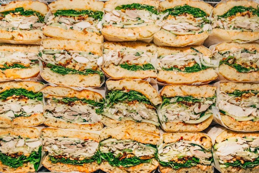 Rows of sandwich halves packed edge to edge, cut sides up, seen from above