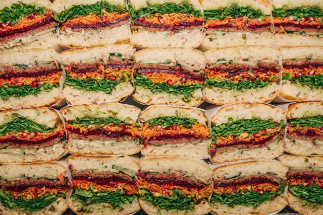 A catering platter with colourful sandwich halves arranged in rows